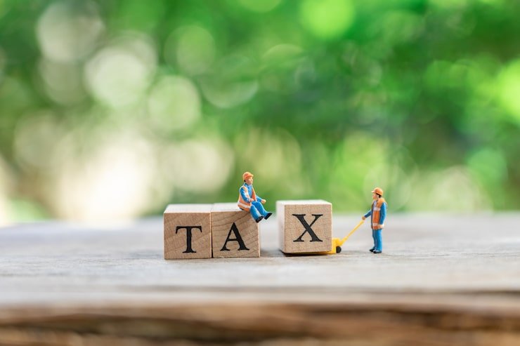 miniature-people-construction-worker-with-wood-word-tax-using_24901-1361